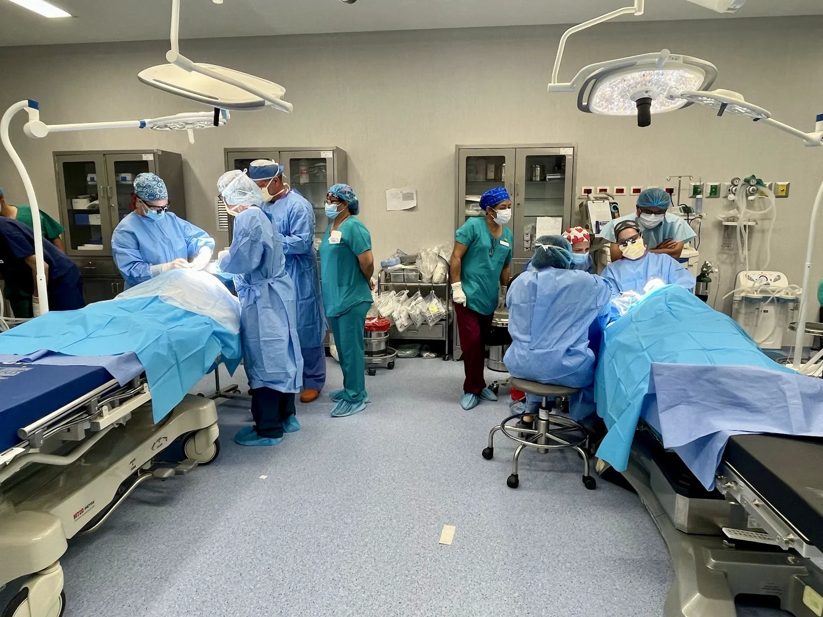 Clinicians work at two operating tables during a VER surgical project.