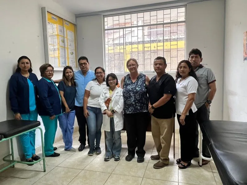 Clinic staff and VER volunteers stand together in an examination room.